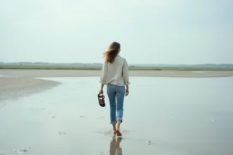 Femme se promenant pieds nus sur les vasières de la baie de Somme au printemps près de Saint-Valery-sur-Somme